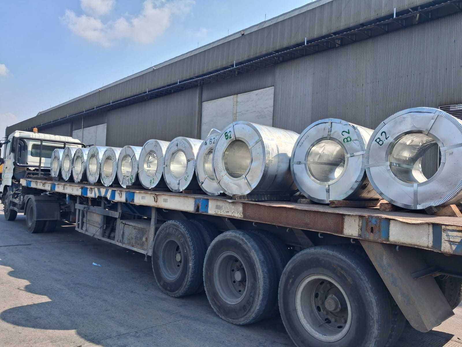 PAL flatbed trailer carrying steel coil cargo at warehouse area